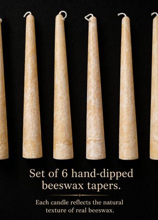 Six hand-dipped beeswax taper candles in a pale natural yellow, displayed against a dark background, highlighting their unique texture and subtle wax bloom patterns.