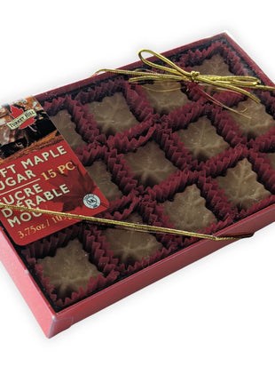 Angled view of the Soft Maple Sugar Candy 15-piece gift box made with pure Canadian maple syrup.  This perspective showcases the elegant gift packaging, clear presentation window, and gold ribbon while emphasizing the premium Canadian maple candy collection.