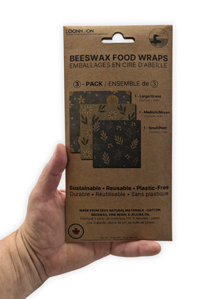 LOONMOON reusable beeswax food wraps retail package held in one hand to demonstrate the actual package size before purchase.  Compact Canadian-made beeswax food wraps that make a practical zero-waste kitchen essential, gift, or environmentally friendly household product.