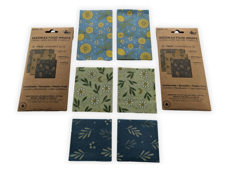 Complete 6-pack reusable beeswax food wraps made in Canada displayed with two retail packages and all six wraps arranged by size and pattern on a white background.  Includes two large, two medium, and two small wraps made from cotton, Canadian beeswax, pine resin, and jojoba oil for sustainable plastic-free food storage, wrapping bread, cheese, fruit, vegetables, and leftovers.