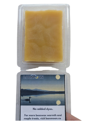 An open LOONMOON beeswax melt clamshell displayed on a white background, showing the natural golden wax inside and the interior insert beneath the lid.  This close-up product image emphasizes the wax texture, simple packaging, and clean presentation of the beeswax melts.
