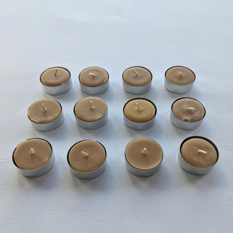 Twelve beeswax tealight candles are displayed in three neat rows from a slightly angled front view on a white background.  This perspective shows the natural wax tops, cotton wicks, compact candle height, and individual aluminum tealight cups more clearly than an overhead image alone.