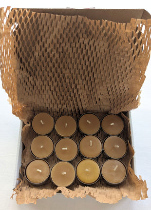 An open kraft box contains twelve beeswax tealight candles arranged in three rows and protected with expandable honeycomb paper wrapping.  The image shows exactly how the 12-pack is presented and packed, including the natural beeswax colour, cotton wicks, aluminum cups, and plastic-free paper cushioning.