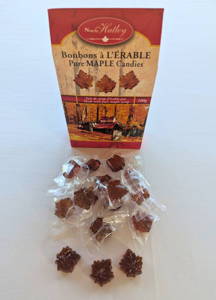 Assortment of individually wrapped Canadian hard maple candies showing the maple-leaf-shaped amber candies through their clear wrappers. Made with pure maple syrup, these Canadian maple candies are individually packaged for convenient sharing, gifting or enjoying one piece at a time.