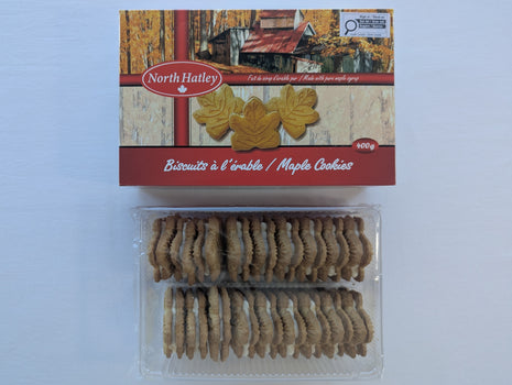 A 400 g box of Canadian maple cream cookies displayed above the opened tray, showing two rows of maple-leaf-shaped sandwich cookies with cream filling. Made with pure maple syrup, this Canadian cookie assortment shows the generous quantity and actual contents inside the package.