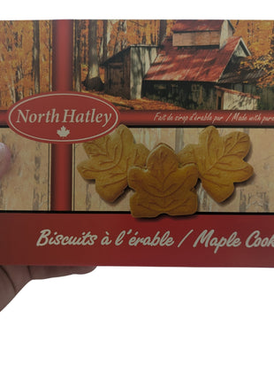 A 400 g box of Canadian maple cream cookies held in one hand to show the size and scale of the package. The Canadian-made cookies are shaped like maple leaves and made with pure maple syrup, making the box suitable as a Canadian food gift, souvenir or maple treat.