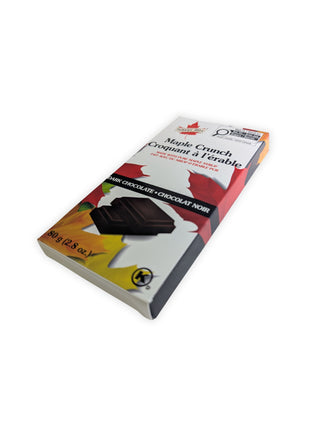 Angled view of the Canadian Maple Crunch dark chocolate bar package made with pure maple syrup.  Angled perspective of the Canadian Maple Crunch Dark Chocolate Bar highlighting the retail packaging and premium presentation of this Canadian maple chocolate treat.