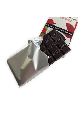Unwrapped Canadian Maple Crunch dark chocolate bar partially removed from its silver wrapper.  Canadian Maple Crunch Dark Chocolate Bar partially unwrapped to reveal the rich dark chocolate inside, allowing customers to see the actual product before purchase.