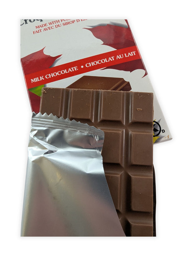 Canadian Maple Crunch milk chocolate bar partially unwrapped to reveal smooth milk chocolate made with pure Canadian maple syrup.  Opening the wrapper showcases the rich milk chocolate and gives customers a closer look at the premium confection inside.