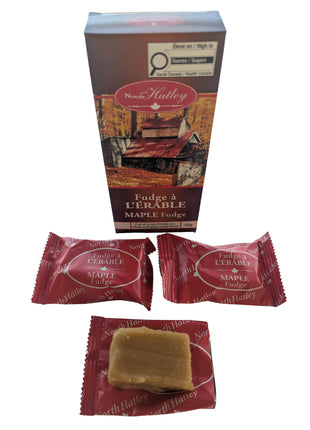 Canadian maple fudge displayed with its 60 g package, showing two individually wrapped pieces and one unwrapped piece of creamy maple fudge. Made in Canada with pure maple syrup, cream and butter, these individually wrapped fudge pieces make a distinctive Canadian maple sweet or food gift.