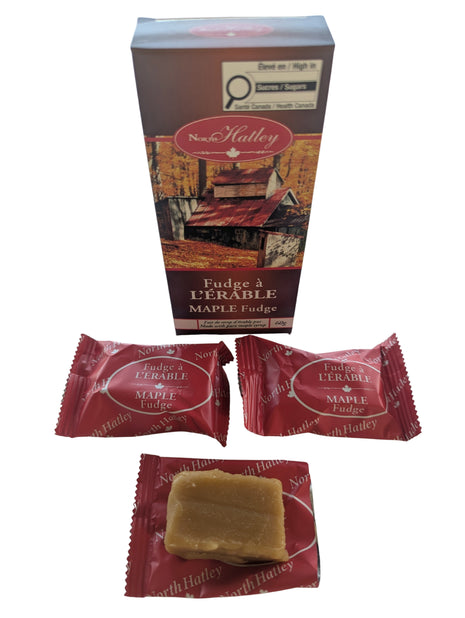 Canadian maple fudge displayed with its 60 g package, showing two individually wrapped pieces and one unwrapped piece of creamy maple fudge. Made in Canada with pure maple syrup, cream and butter, these individually wrapped fudge pieces make a distinctive Canadian maple sweet or food gift.