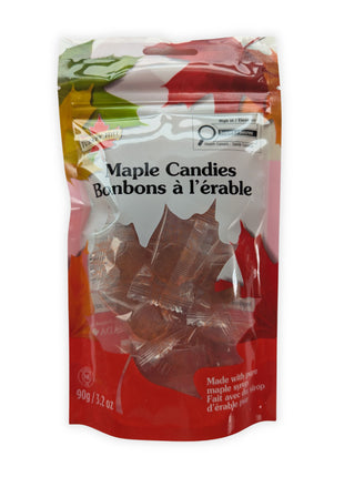 A front view of a 90 g resealable package of maple hard candies made with pure maple syrup, photographed on a clean white background.  The bilingual Maple Candies and Bonbons à l’érable label is clearly visible, along with the red maple-leaf packaging and individually wrapped amber maple-leaf candies shown through the transparent window.