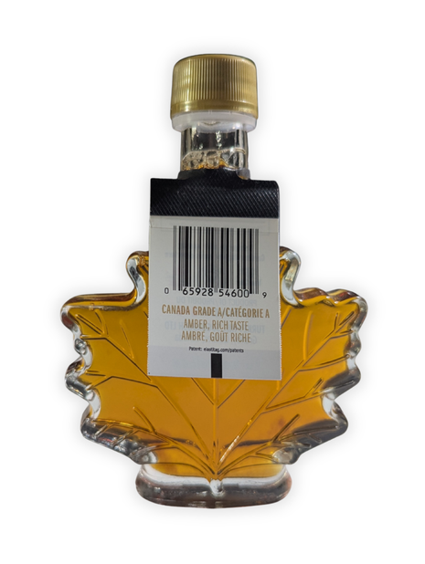 Back view of a 100 ml Canadian maple syrup leaf bottle showing the Canada Grade A Amber Rich Taste label and barcode.  Authentic Canadian maple syrup packaged in a traditional maple leaf bottle with product grading information for shoppers seeking genuine maple syrup from Canada.