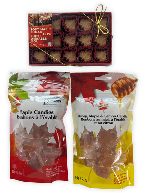 Canadian maple treat sampler featuring a 15-piece box of soft maple sugar candies, traditional maple candies, and honey, maple and lemon candies arranged together on a clean white background.  This complete product view clearly shows the three Canadian-made maple treats included in the sampler and their colourful retail packaging.