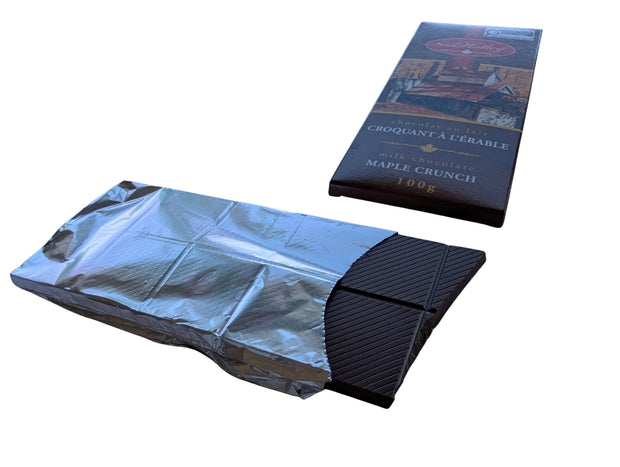 Unwrapped Milk Chocolate Maple Crunch bar displayed with its Canadian maple-themed package, showing the chocolate squares and silver wrapper. A Canadian-made milk chocolate treat featuring maple sugar.