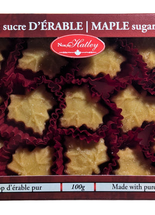 Front view of a 100 g box of Canadian maple sugar candies, with maple-leaf-shaped candies visible through the package window. Made in Canada with pure maple syrup, these traditional maple candies showcase the flavour of Canadian maple.