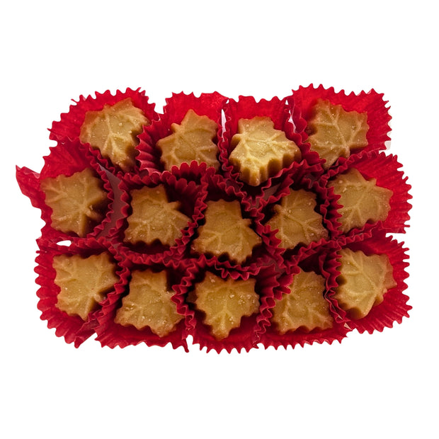 Maple-leaf-shaped Canadian maple sugar candies displayed outside their package in individual red paper cups. Made with pure maple syrup, these traditional Canadian maple candies have a naturally golden maple colour.