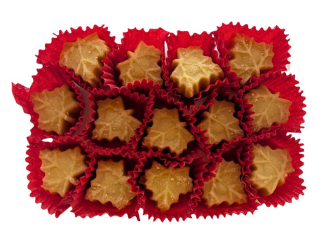 Maple-leaf-shaped Canadian maple sugar candies displayed outside their package in individual red paper cups. Made with pure maple syrup, these traditional Canadian maple candies have a naturally golden maple colour.
