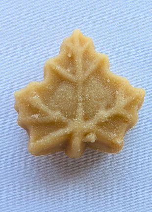 Close-up of an individual maple-leaf-shaped Canadian maple sugar candy showing its moulded leaf detail and natural maple texture. Made from pure maple syrup, each piece offers a concentrated taste of Canadian maple.