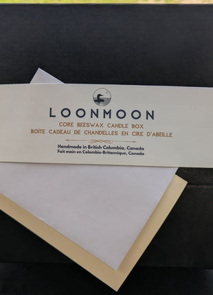 Close-up of LOONMOON Core Beeswax Candle Box label with blank greeting card and envelope for a Canadian candle gift.
