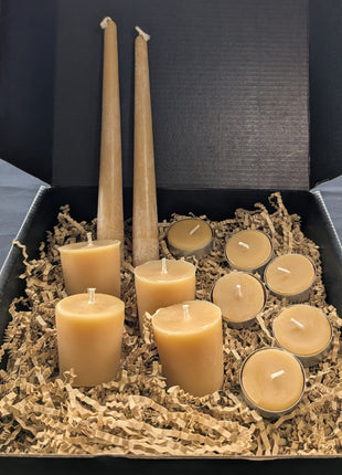 Open LOONMOON beeswax candle gift box with pure beeswax tapers, votives, and tealights packed in kraft crinkle paper.