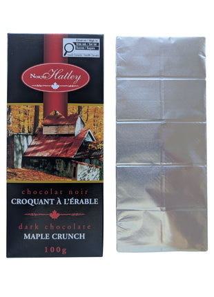 A Dark Chocolate Maple Crunch bar shown beside its package with the silver wrapper removed to reveal the segmented dark chocolate bar. This 100 g Canadian chocolate treat combines dark chocolate with maple sugar.