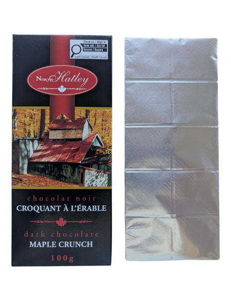 A Dark Chocolate Maple Crunch bar shown beside its package with the silver wrapper removed to reveal the segmented dark chocolate bar. This 100 g Canadian chocolate treat combines dark chocolate with maple sugar.