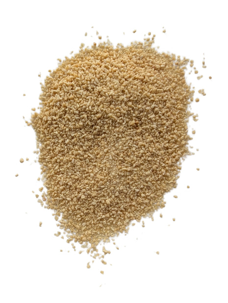 A detailed close-up of loose fine maple sugar on a clean white background, showing its natural light golden colour, small irregular granules and dry crystalline texture for an accurate view of the product outside the package.