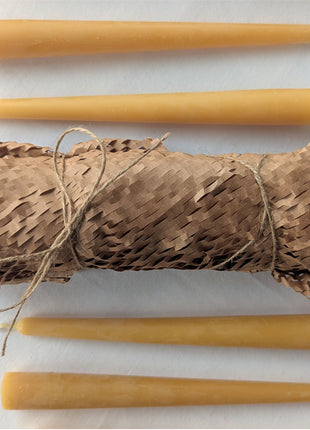 Natural beeswax taper candles arranged around a kraft-paper-wrapped candle set tied with rustic twine for the LOONMOON Premium Candle Gift Box.  The warm golden tapers and recyclable paper presentation emphasize the box’s thoughtful Canadian-made gift styling and natural beeswax appeal.