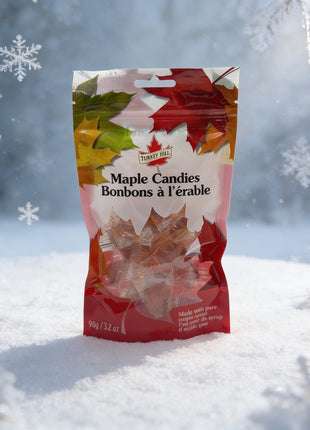 Bag of Canadian maple candies made with pure maple syrup set in a snowy winter forest scene with falling snowflakes