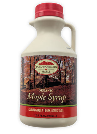 A front view of a 500 mL Echo Mountain organic maple syrup jug on a clean white background.  The cream-coloured jug has a red cap, built-in handle and pouring spout, with an autumn sugar-bush label identifying the syrup as Canada Grade A, dark with a robust taste.