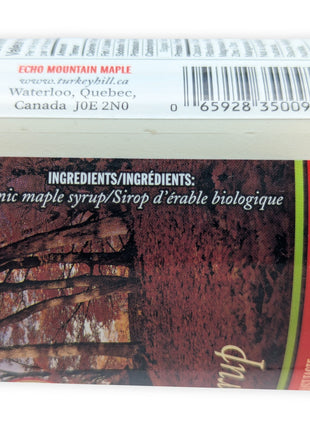 Close-up of the label on a 500 mL organic maple syrup jug showing the bilingual ingredient statement, organic maple syrup and sirop d’érable biologique, along with the Echo Mountain Maple producer information, Waterloo, Quebec address and product barcode.