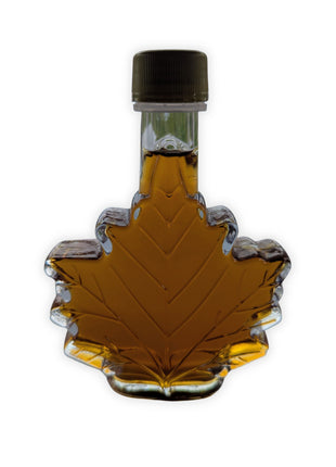 Pure Canadian maple syrup in a traditional maple leaf glass bottle displayed on a clean white background.  Authentic amber maple syrup made in Canada, perfect for pancakes, waffles, baking, gifts, and anyone looking for genuine Canadian maple syrup.