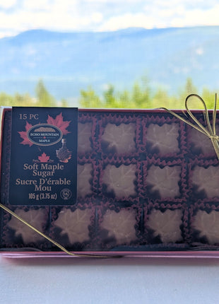 15-piece soft maple sugar candy gift box made in Canada displayed against a scenic Canadian mountain landscape, featuring individually wrapped maple leaf candies in a premium red gift box.  Authentic Canadian maple syrup candy inspired by Canada's natural beauty and perfect as a Canadian souvenir or gift.