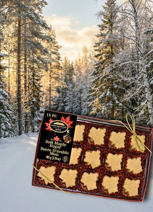 Soft maple sugar candies in a gift box set against a snowy Canadian forest with warm, golden sunlight, evoking a cozy winter scene, showcasing authentic Canadian maple treats