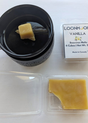 LOONMOON Vanilla beeswax melts shown with a black wax warmer, one wax cube placed in the warmer dish, the closed clamshell package, and the open clamshell displaying the natural wax inside.  This image helps shoppers visualize the vanilla beeswax melts in use while clearly showing the packaging and wax texture.